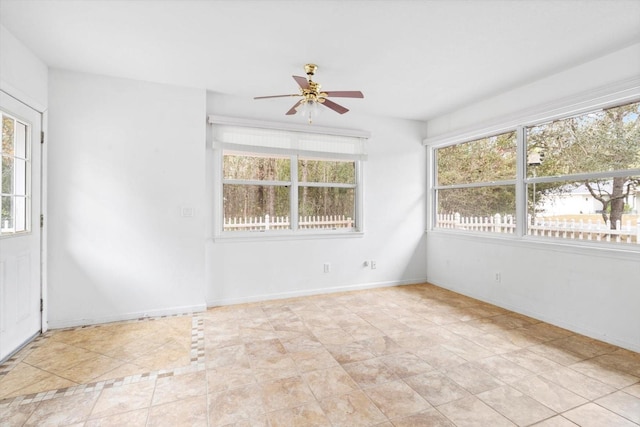 empty room with ceiling fan and light tile patterned floors