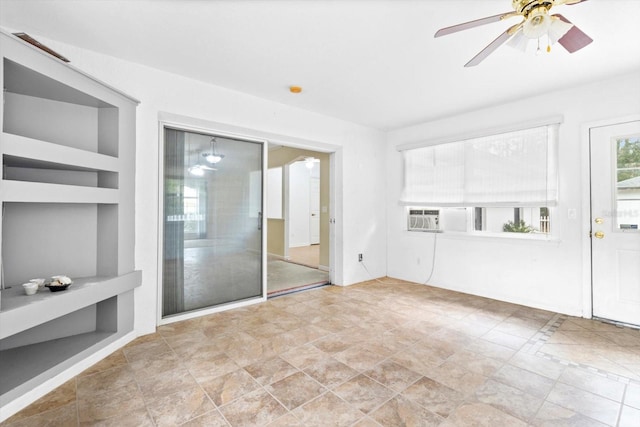 unfurnished living room with built in features, ceiling fan, and cooling unit