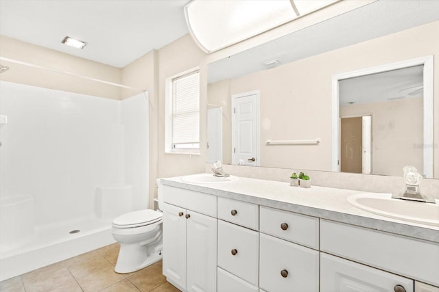 bathroom with tile patterned flooring, vanity, toilet, and walk in shower