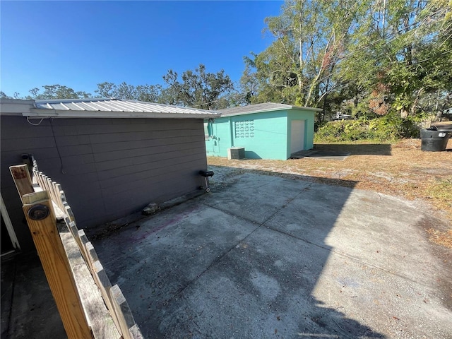 view of property exterior with central AC and a patio