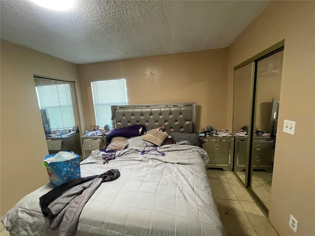 tiled bedroom featuring a closet and a textured ceiling