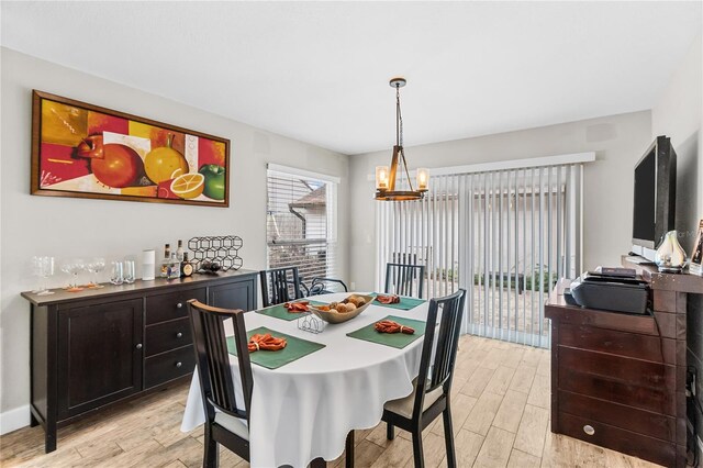 dining room with an inviting chandelier and light hardwood / wood-style flooring