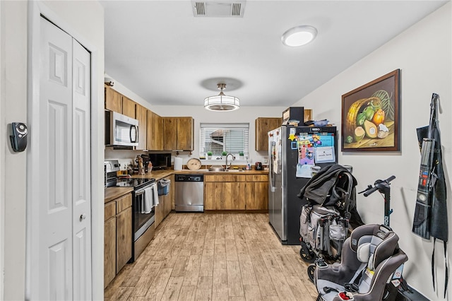 kitchen featuring sink, stainless steel appliances, and light hardwood / wood-style floors