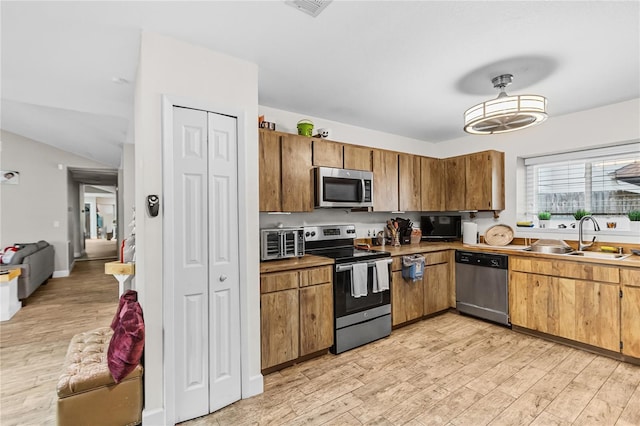 kitchen featuring sink, appliances with stainless steel finishes, and light hardwood / wood-style flooring