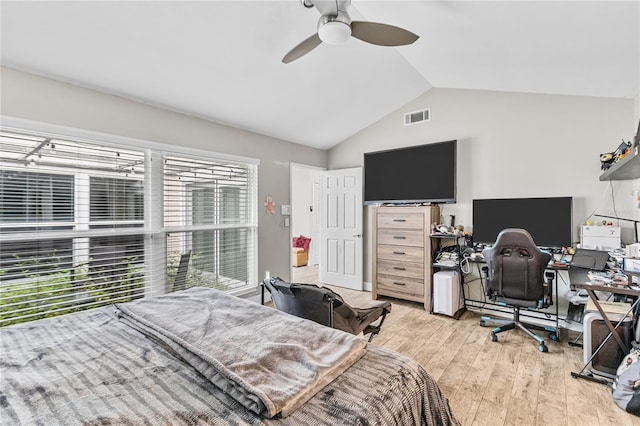 bedroom with ceiling fan, light hardwood / wood-style floors, and vaulted ceiling