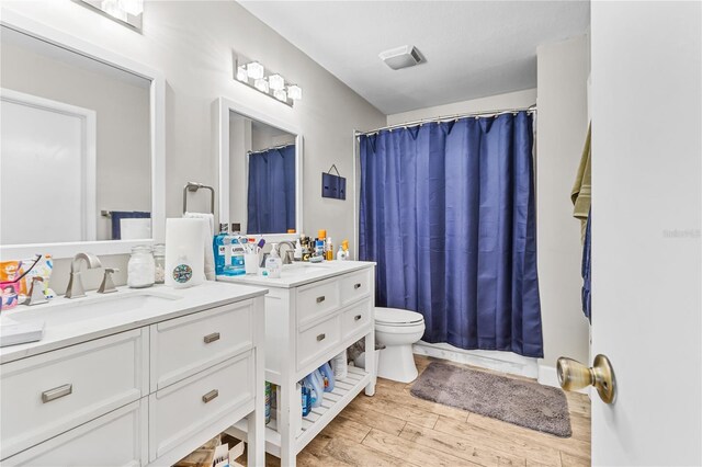 bathroom featuring hardwood / wood-style flooring, vanity, and toilet