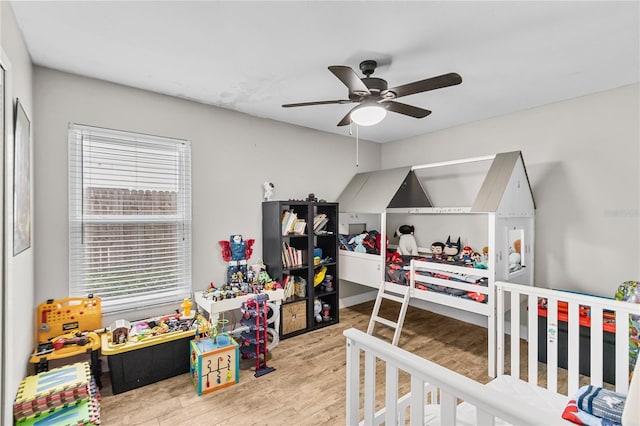 bedroom featuring ceiling fan, light wood-type flooring, and multiple windows