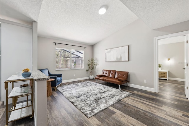 living area with a textured ceiling, dark wood-type flooring, and lofted ceiling