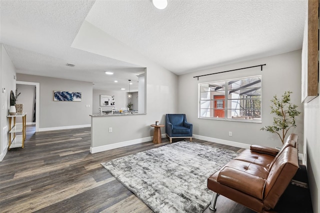 living area with lofted ceiling, a textured ceiling, and dark wood-type flooring