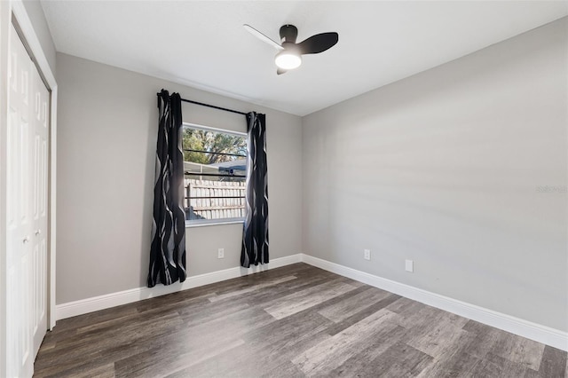 empty room with ceiling fan and dark hardwood / wood-style floors