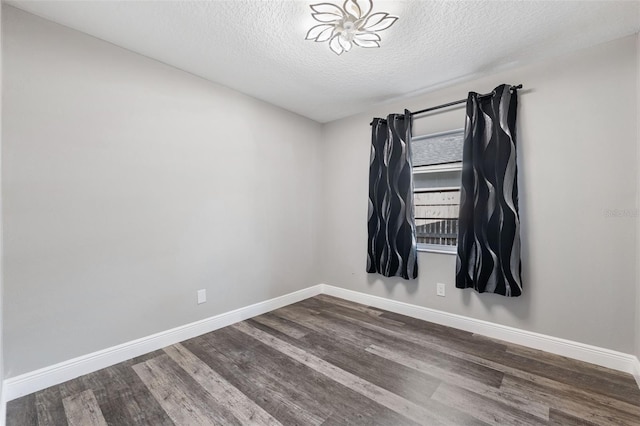 empty room featuring a textured ceiling and dark hardwood / wood-style floors