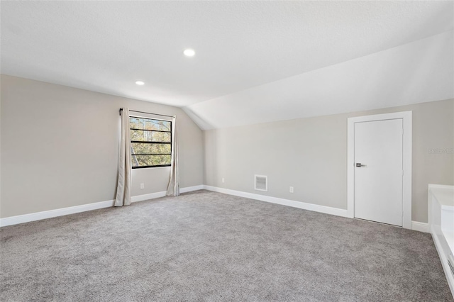 bonus room with carpet flooring and vaulted ceiling