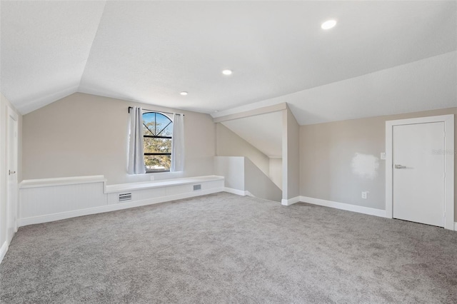 additional living space featuring carpet, a textured ceiling, and lofted ceiling