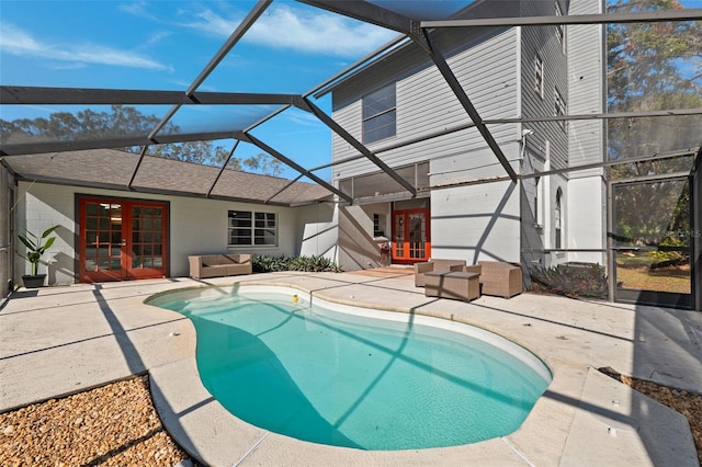 view of pool with french doors, a lanai, and a patio area