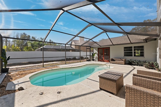 view of swimming pool featuring french doors, glass enclosure, and a patio area