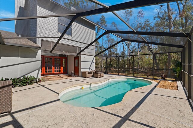 view of pool featuring a lanai, a patio area, and french doors