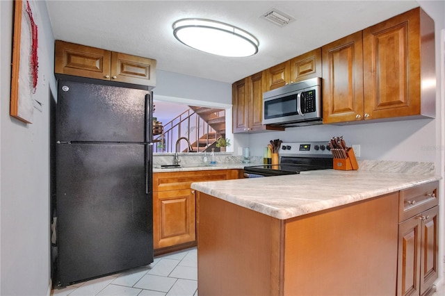 kitchen with kitchen peninsula, sink, light tile patterned flooring, and stainless steel appliances