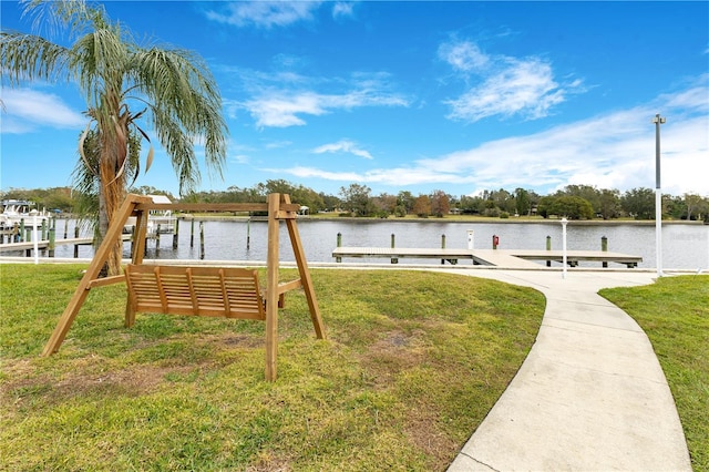 dock area with a lawn and a water view