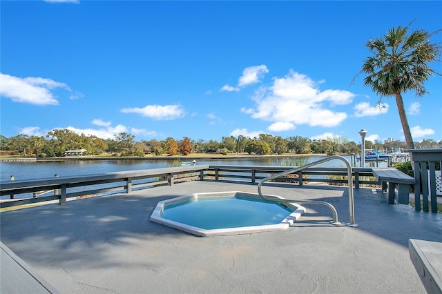 view of swimming pool with a water view and a jacuzzi