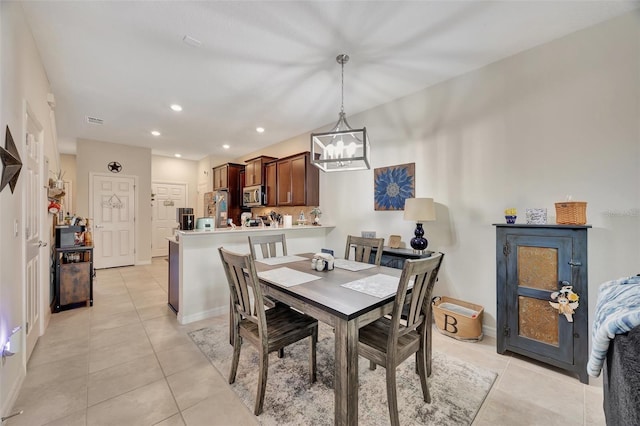 dining area with a chandelier and light tile patterned floors