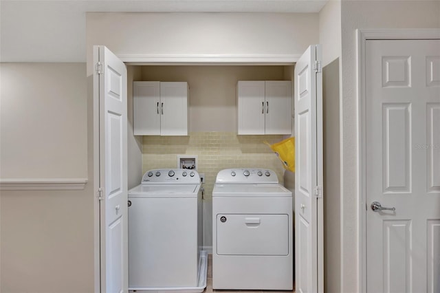 washroom featuring washer and dryer and cabinets