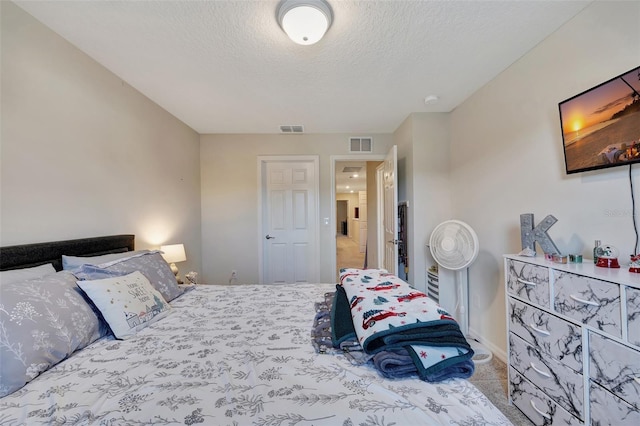 bedroom featuring a textured ceiling and light carpet