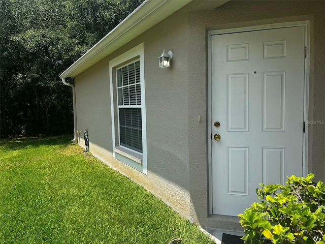 property entrance featuring a lawn