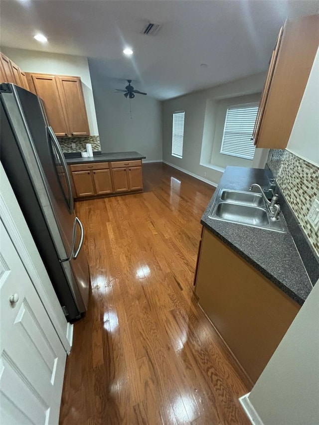 kitchen with refrigerator, tasteful backsplash, ceiling fan, sink, and light hardwood / wood-style floors