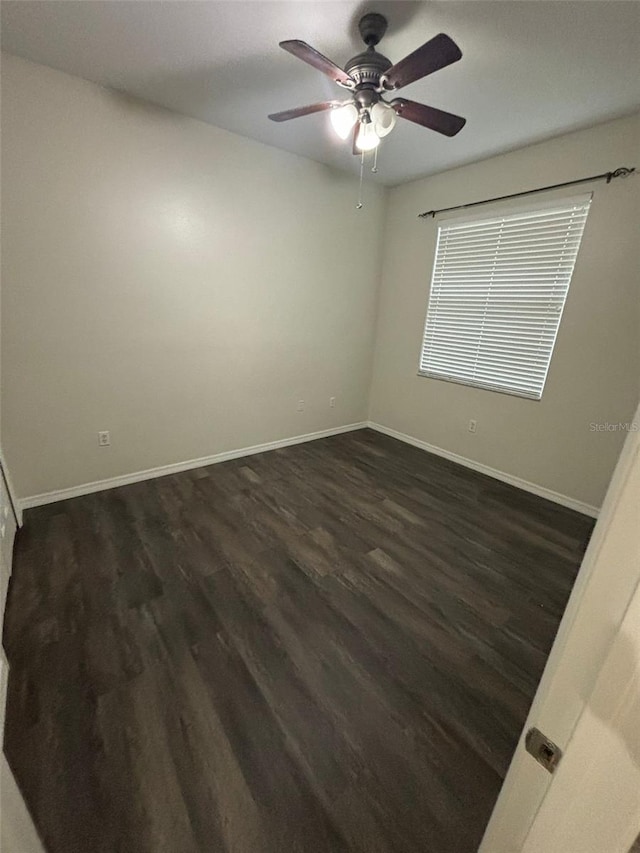 spare room featuring ceiling fan and dark wood-type flooring