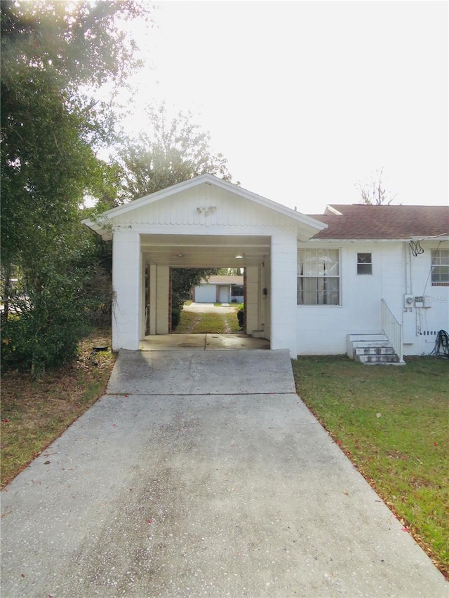 ranch-style home featuring a carport and a front yard