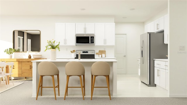 kitchen featuring white cabinets, a kitchen breakfast bar, stainless steel appliances, and kitchen peninsula