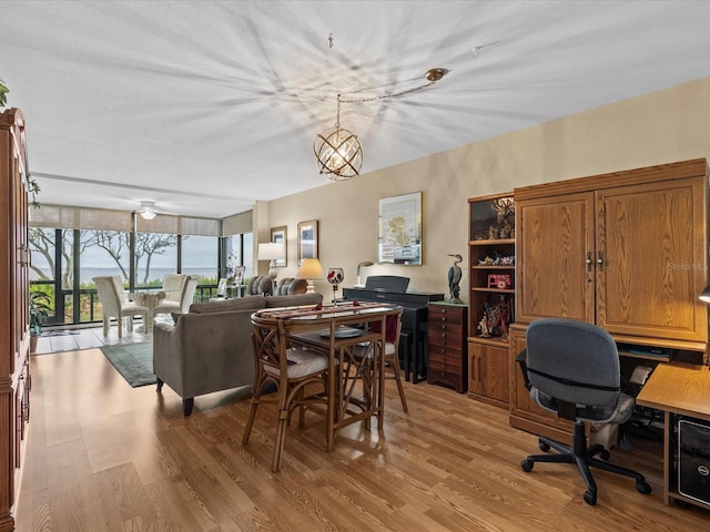 dining room featuring light hardwood / wood-style flooring and ceiling fan with notable chandelier