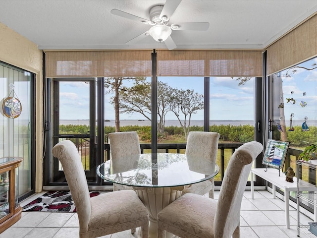 sunroom with ceiling fan, a water view, and a wealth of natural light