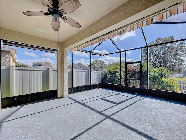 unfurnished sunroom featuring ceiling fan