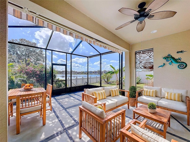 sunroom / solarium featuring a water view and ceiling fan