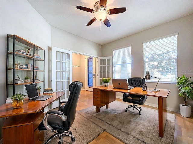 office area with ceiling fan, light hardwood / wood-style floors, and a wealth of natural light