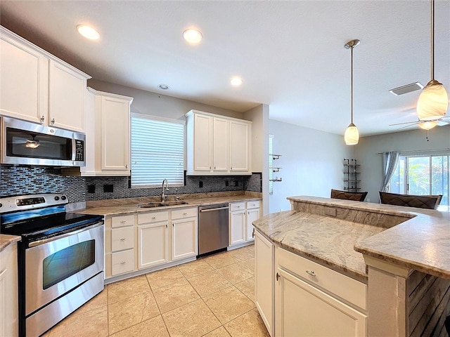 kitchen with decorative light fixtures, sink, white cabinetry, appliances with stainless steel finishes, and light tile patterned floors