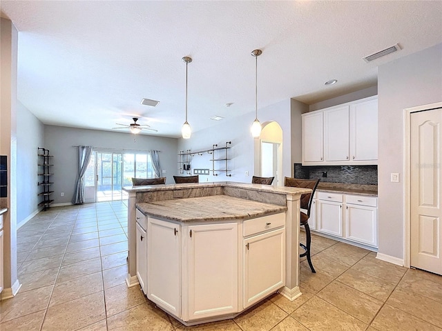 kitchen with hanging light fixtures, white cabinetry, and a kitchen island