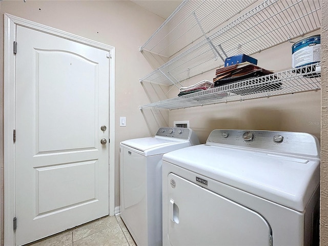 laundry room featuring light tile patterned flooring and washing machine and clothes dryer