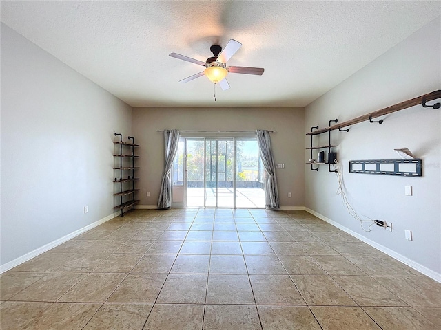 tiled spare room with a textured ceiling and ceiling fan