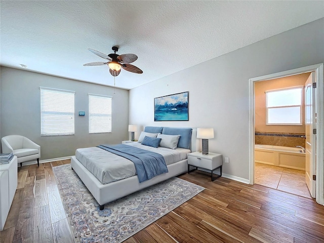 bedroom featuring a textured ceiling, ceiling fan, connected bathroom, and hardwood / wood-style flooring