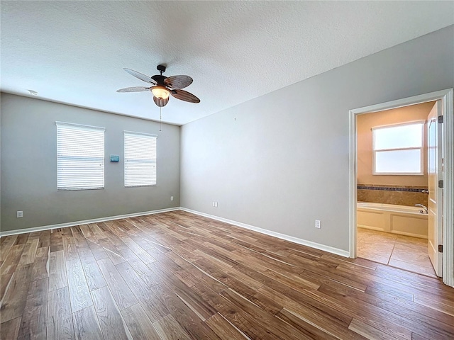 empty room featuring ceiling fan, wood-type flooring, and a textured ceiling