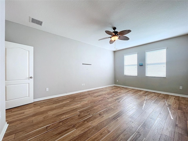 empty room with a textured ceiling, ceiling fan, and hardwood / wood-style floors