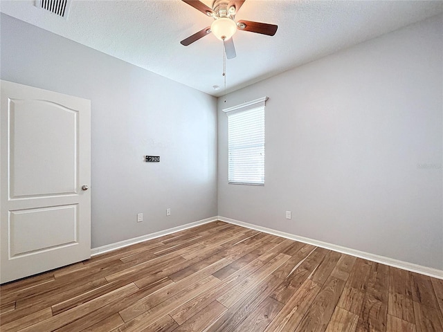 unfurnished room featuring ceiling fan, wood-type flooring, and a textured ceiling