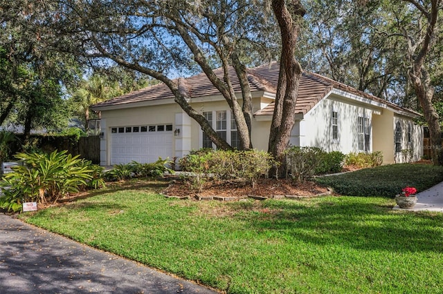 ranch-style house featuring a garage and a front lawn