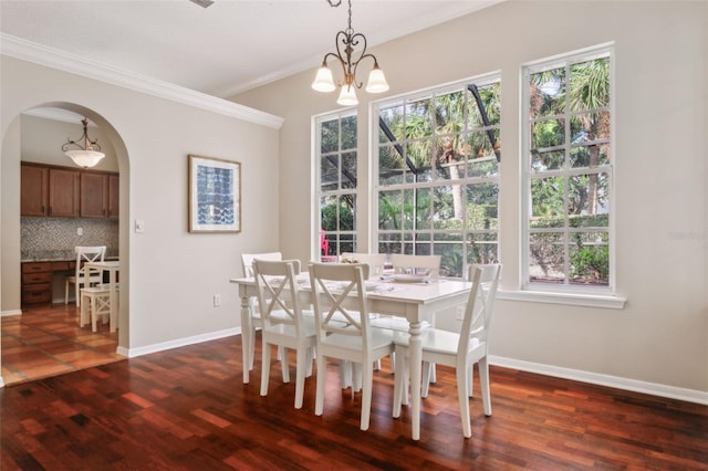 dining area featuring a notable chandelier, crown molding, and dark hardwood / wood-style floors