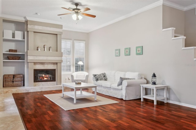 living room with a high end fireplace, ornamental molding, dark hardwood / wood-style floors, and ceiling fan