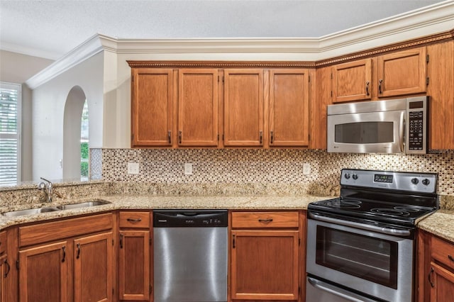 kitchen with tasteful backsplash, appliances with stainless steel finishes, crown molding, and sink