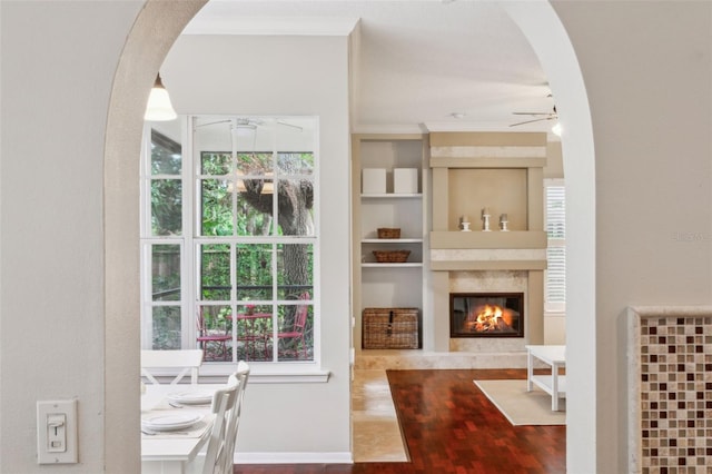 dining space featuring crown molding, a premium fireplace, and ceiling fan