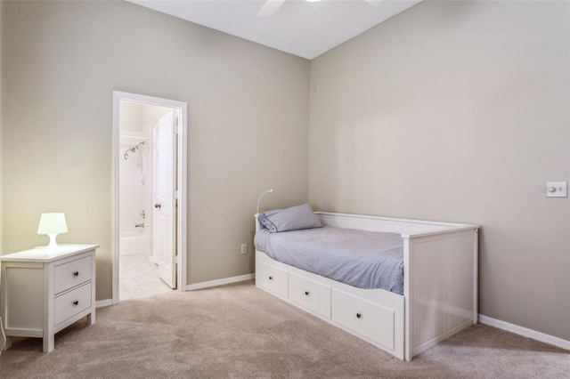 bedroom with ensuite bathroom, light carpet, and ceiling fan